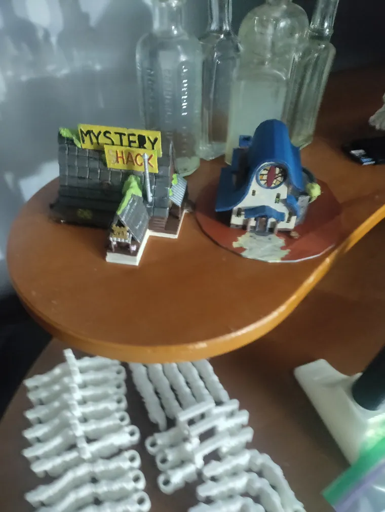 Mystery Shack miniatures beside unpainted prints.