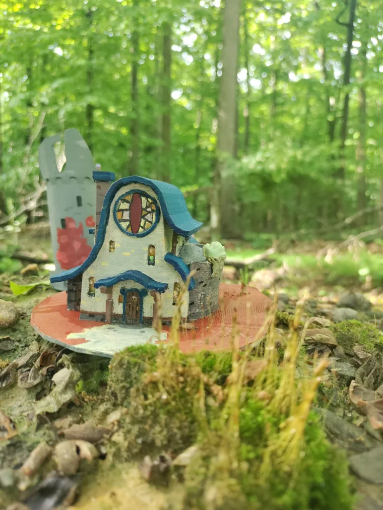 Painted house model photographed outdoors.